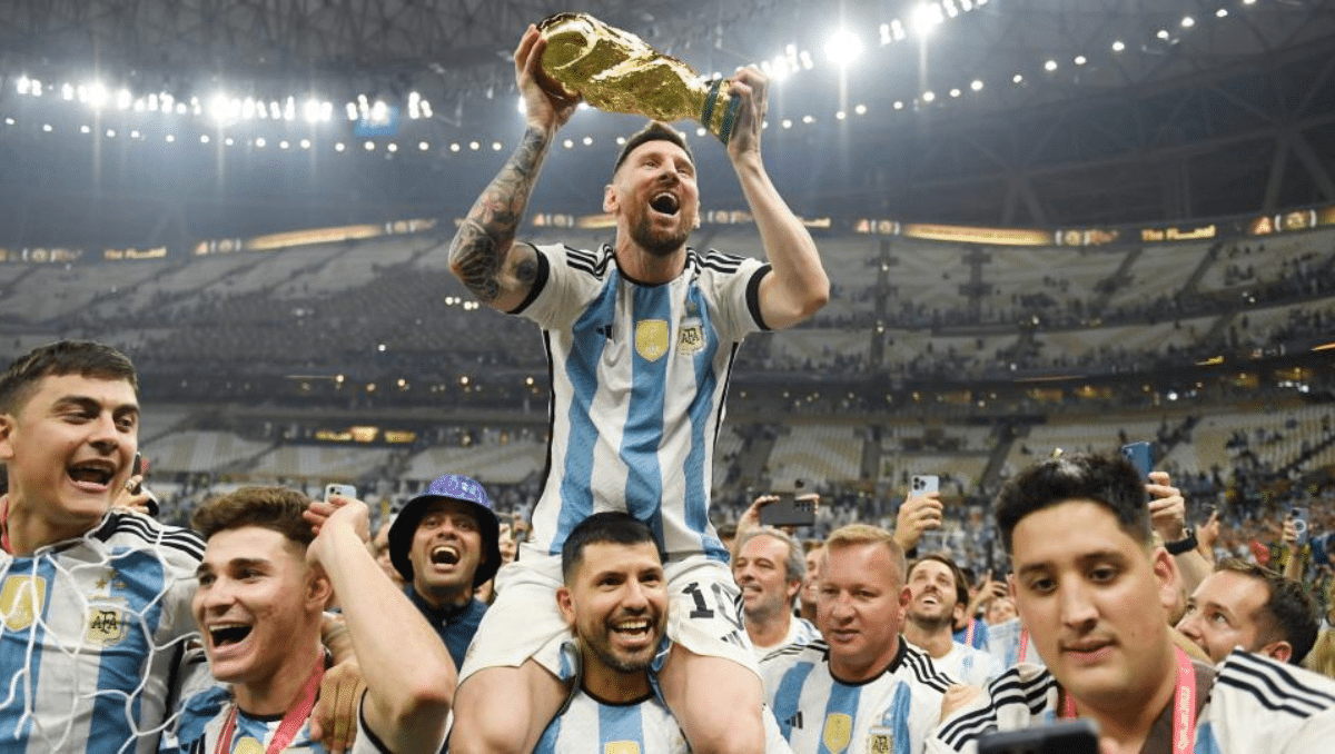Lionel Messi on Sergio Aguero's shoulder holding the World Cup