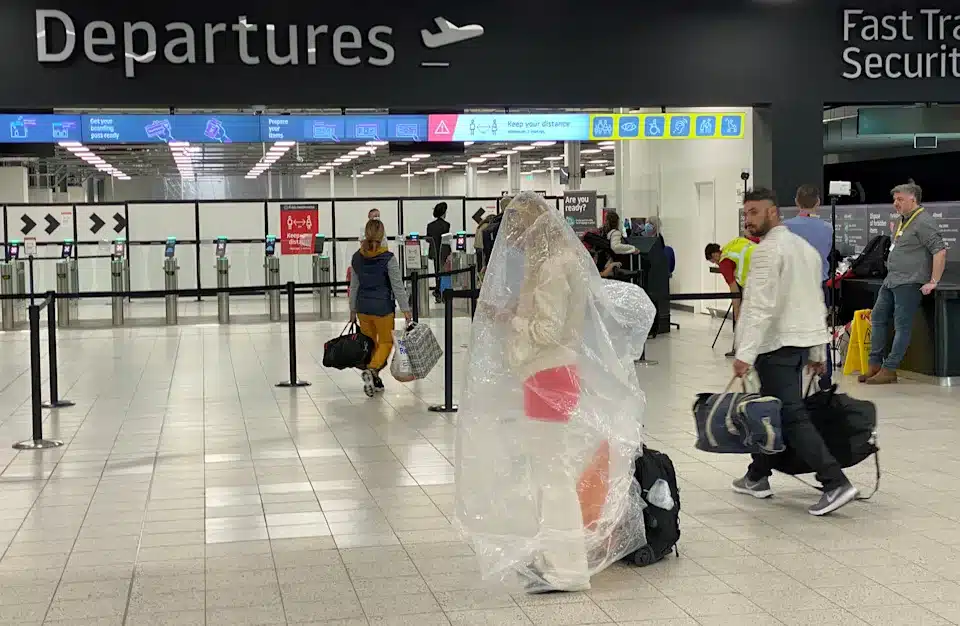 woman covered in plastic covering in an airport