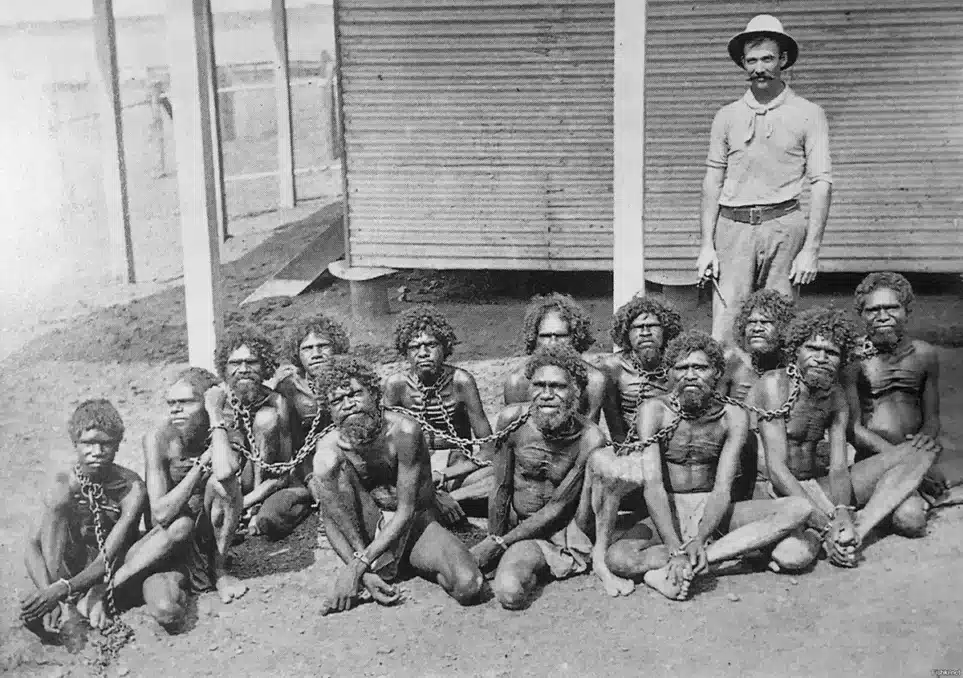 Chained Aboriginals and a British man standing guard at Wyndham Prison in 1902 