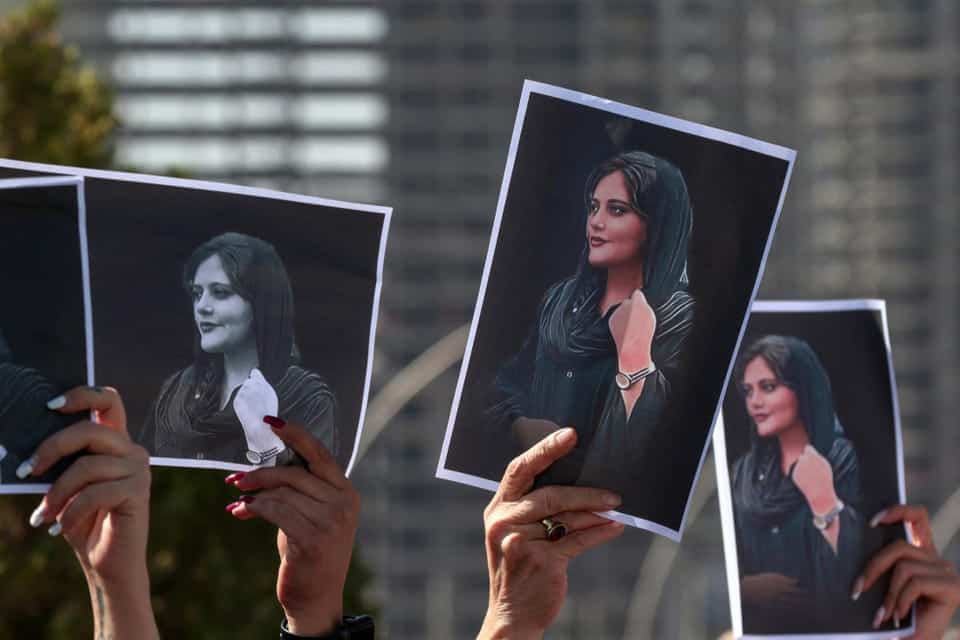 Protestors holding images of Mahsa Amini