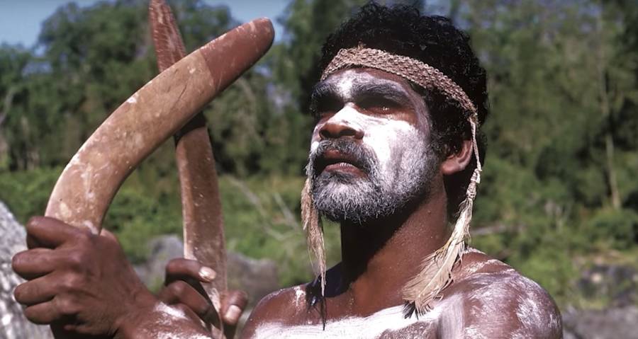 An aboriginal man holding a boomerang 