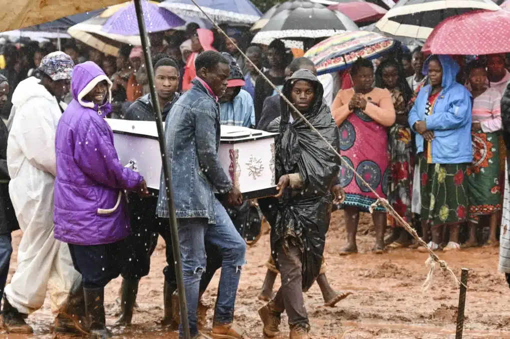 people in funeral procession in Malawi after cyclone freddy.
