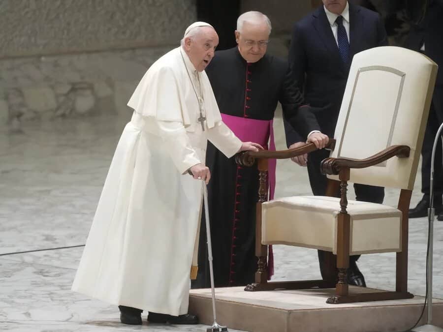 Pope being helped to the seat.