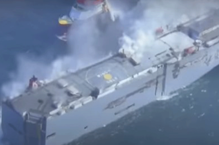 A cargo ship with approximately 3,000 automobiles on board caught fire on Wednesday