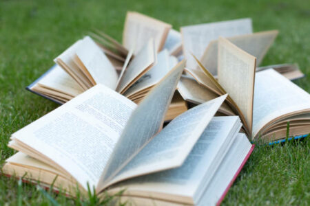 Open books lying on a green grass. The concept of learning outdoors