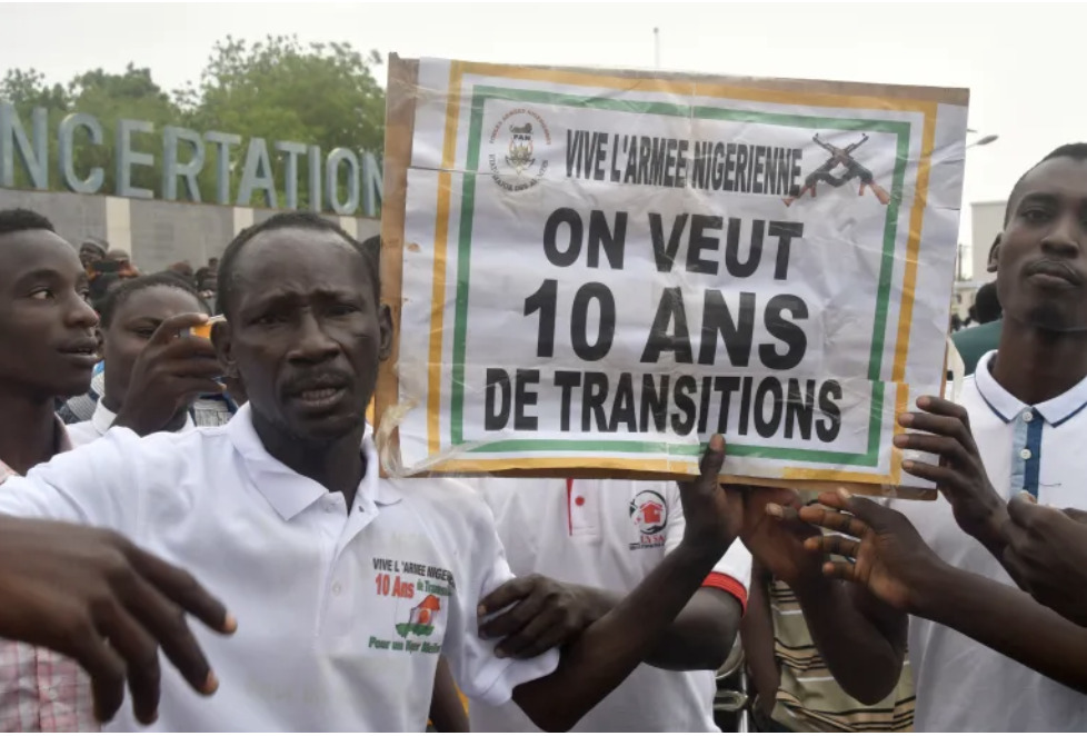 On July 27, 2024, supporters of the Nigerien defence and security forces raise a sign outside the national legislature in Niamey. 