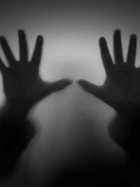 Shadow hands through glass, faceless person, fear