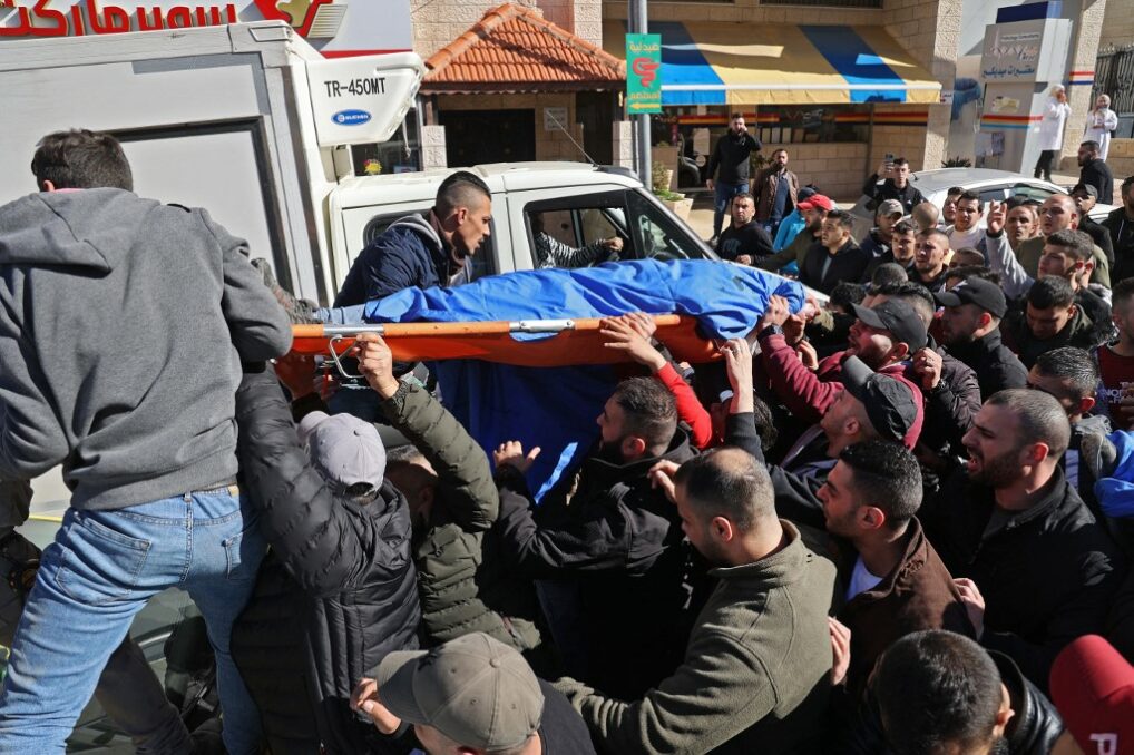 Palestinians carry the dead bodies of those killed by Israel troops