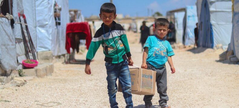 UNICEF/Ali Almatar Brothers Ahmad (left), 7, and Saad, 5, carry a hygiene kit from the Aid delivery back to their tent in Fafin camp, northern SYria