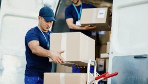 moving-labourers-unloading-cardboard-boxes-from-delivery-truck