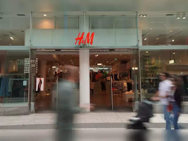 Photo of an H&M store with people walking past in a blur