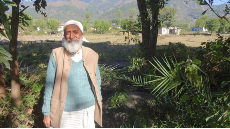 Kulbushan Upmanyu, an environmentalist who was also a part of the Chipko movement in the '80s, poses for a photo in a village adjacent to the hills (Image Source: Indian Express)