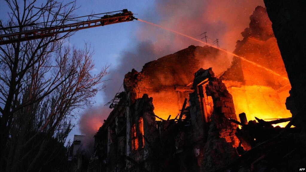  In a handout photograph taken and released by the Ukrainian Emergency Service on July 20, 2024, rescuers can be seen extinguishing a fire at a residential building severely damaged by a missile strike in the center of Mykolaiv.