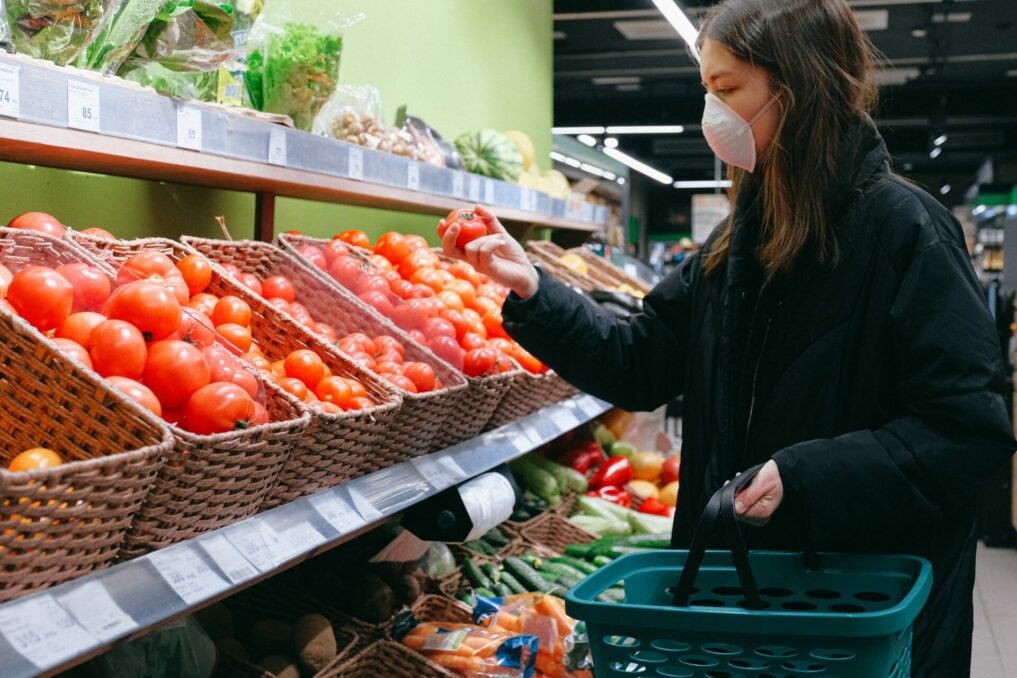 Woman in Face Mask Shopping in Supermarket due to covid

