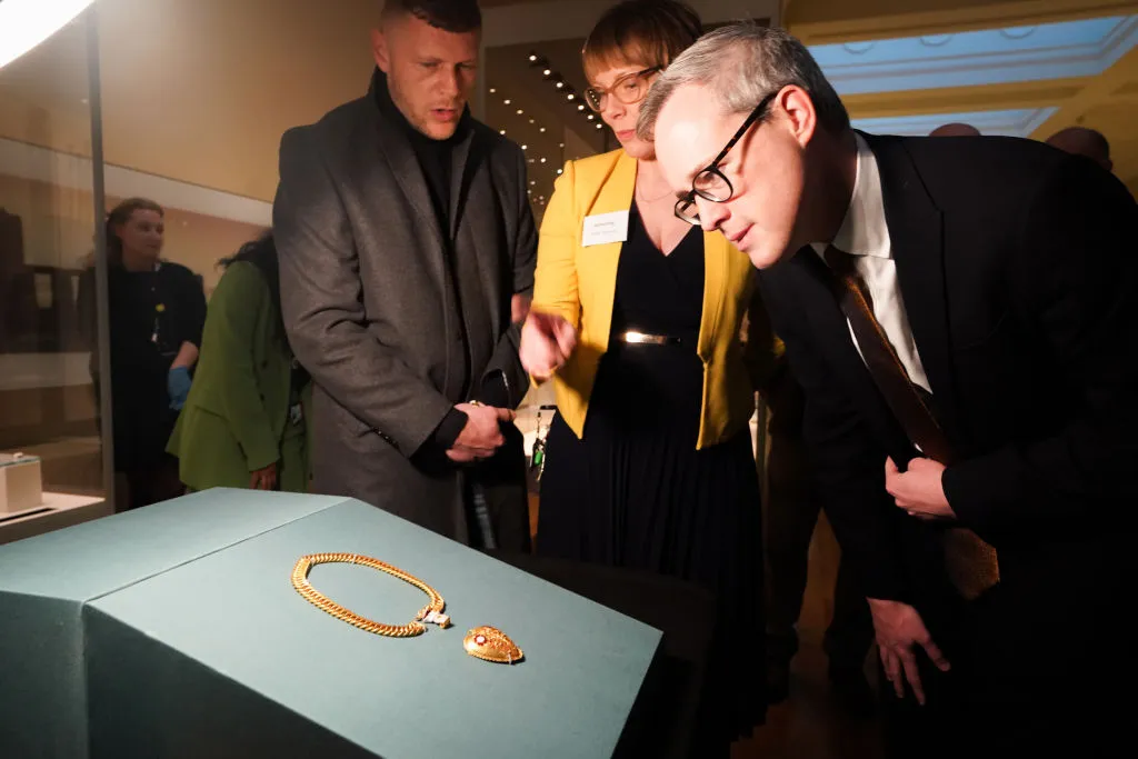 Charlie Clarke (left), and Arts and Heritage Minister, Lord Parkinson of Whitley Bay (right), examine the pendant on display at the British Museum in London.
