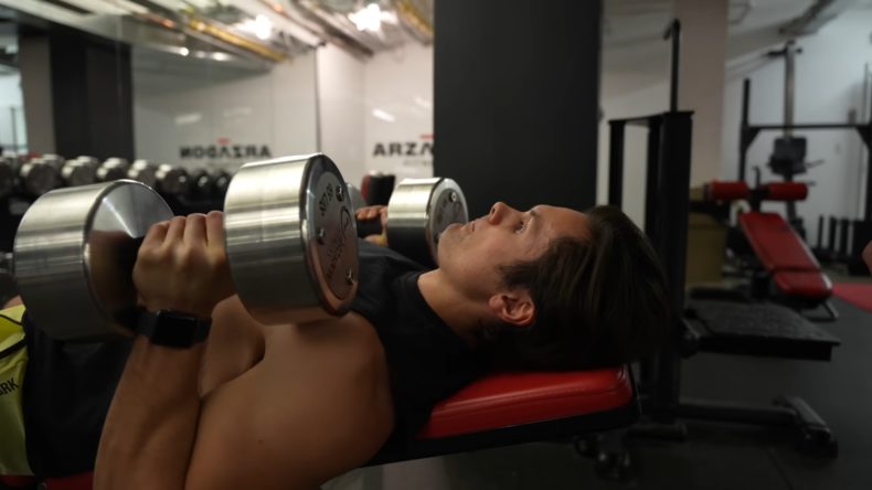 A Man Bench Pressing in A Well-Equipped Gym, Focused on His Workout