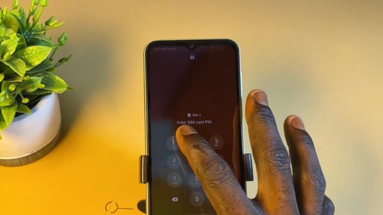 A Person Entering a SIM Card PIN on A Smartphone Screen, Unlocking the Phone for Use with Different Carriers