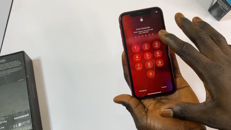 A Person Entering a Passcode on A Locked I Phone Screen, Preparing to Unlock the Device